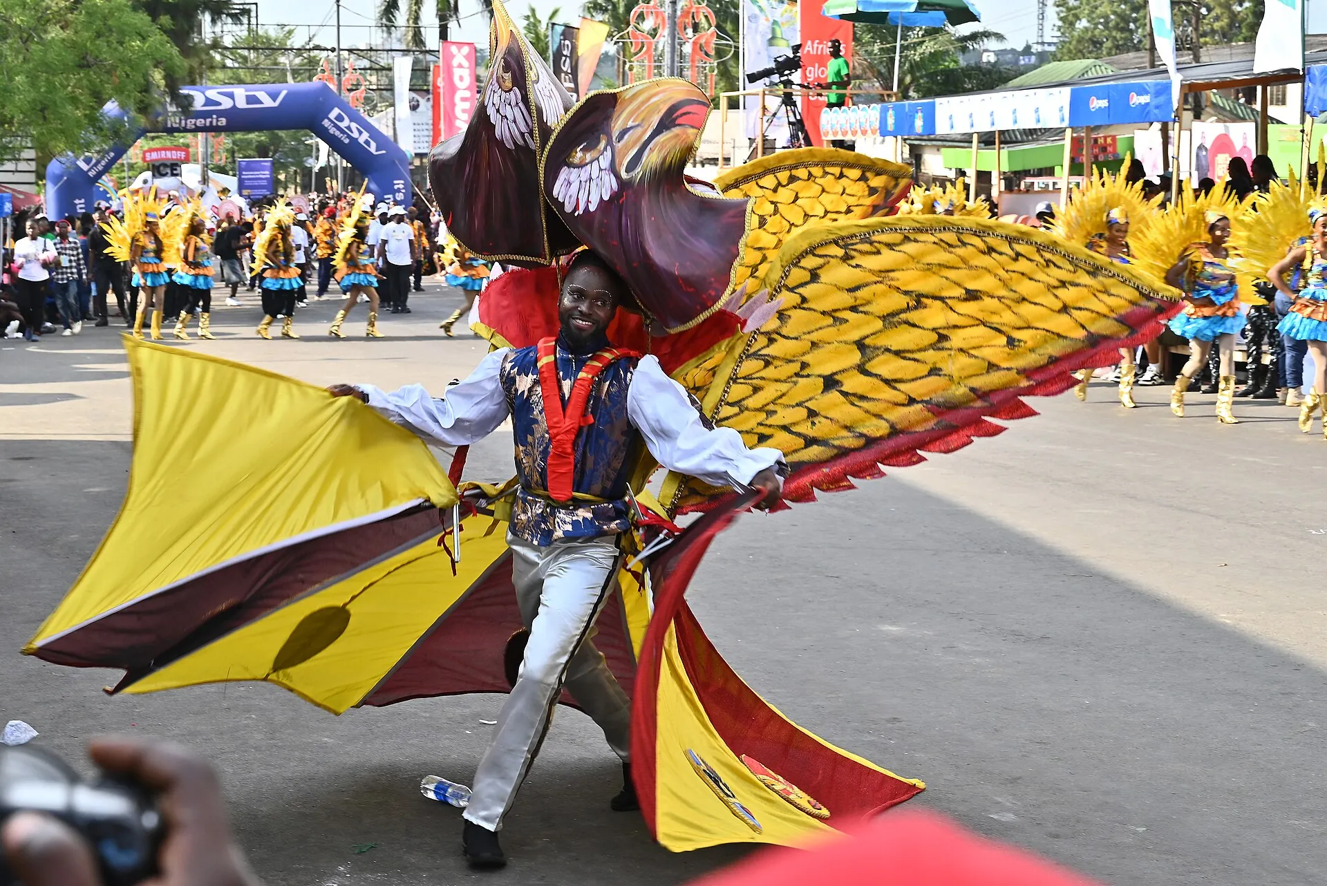 A Calabar Carnival dancer in a costume of yellow, red, and black wings.