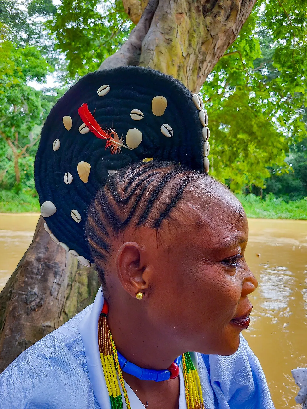 A woman at the Osun Osogbo festival with braided agogo hair crowned with beads and gold.