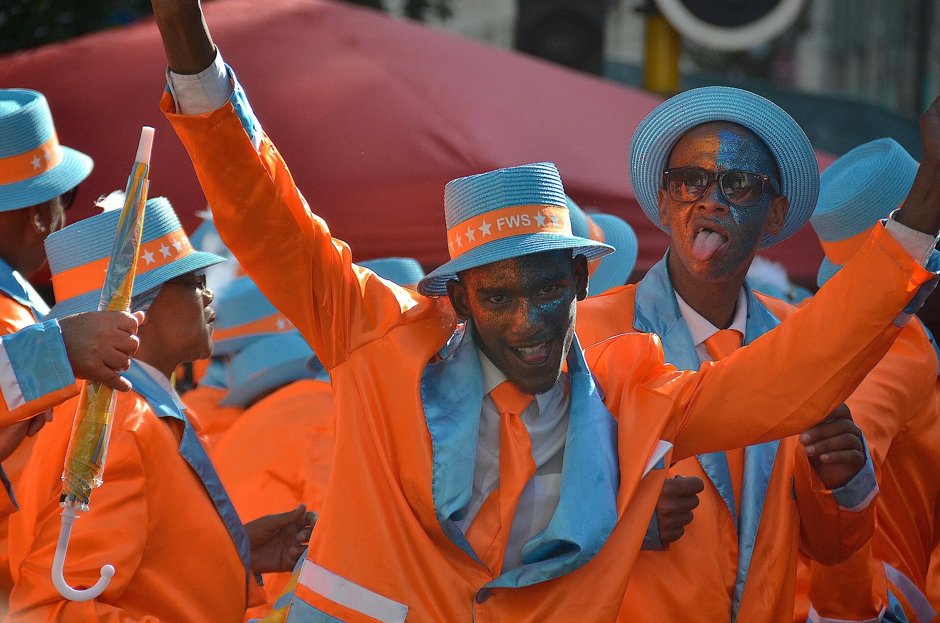 Performers at the Cape Minstrel Carnival in Cape Town in matching orange and blue suits and hats.