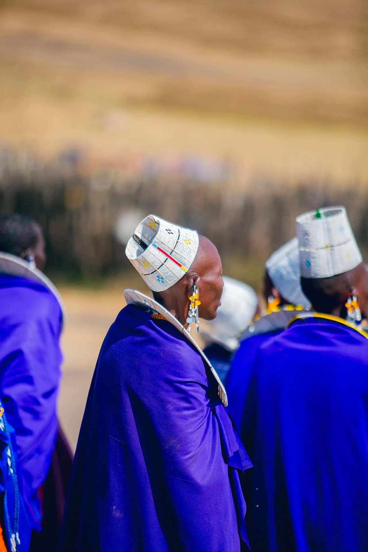 Maasai women in Ngorongoro, Tanzania, in royal blue and purple shúkà with white beaded headdresses.